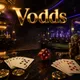 Vodds online casino hero banner with gold chips, playing cards, and ruby dice on dark marble under cinematic casino lighting
